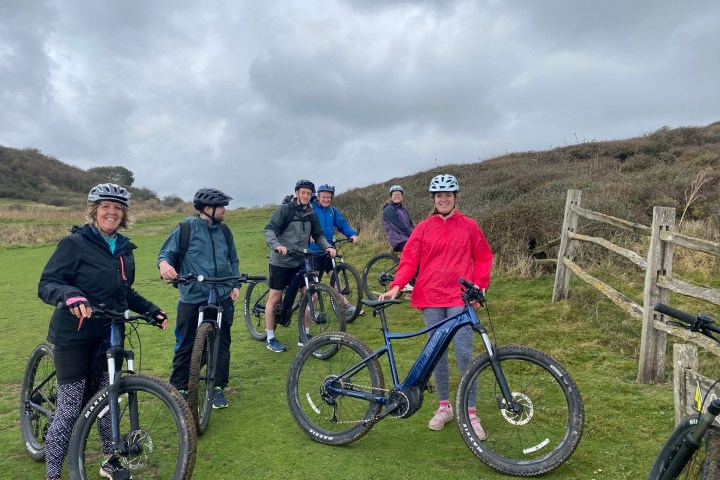 a group of people standing next to a bicycle