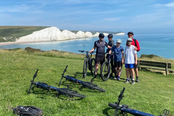 a group of people standing on top of a grass covered field