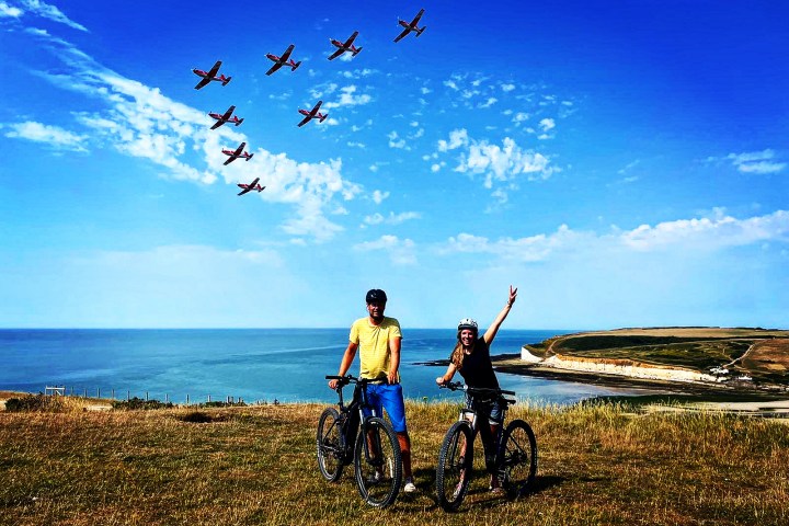 a group of people flying kites on a beach