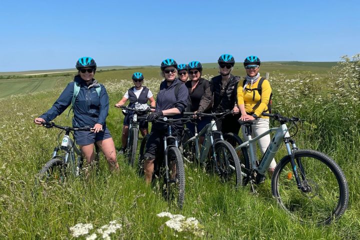 a group of people standing next to a bicycle