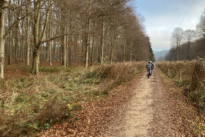 a man riding a bike down a dirt road